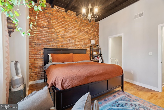 bedroom with visible vents, beamed ceiling, wood finished floors, wooden ceiling, and baseboards