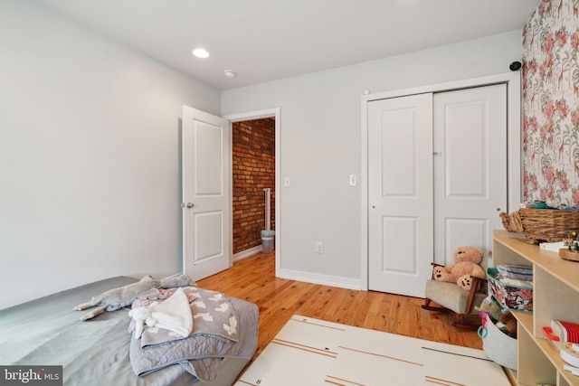 bedroom featuring a closet, light wood-type flooring, and baseboards