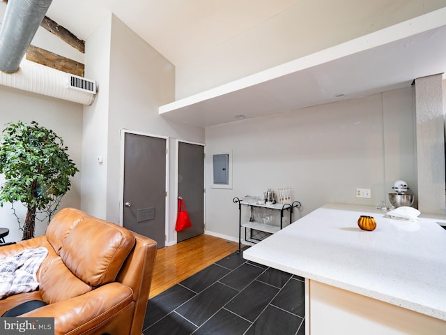 interior space featuring hardwood / wood-style floors, electric panel, and vaulted ceiling