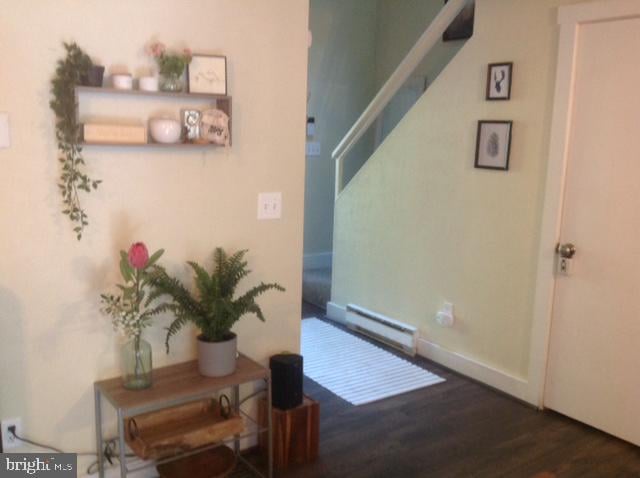 hallway featuring dark hardwood / wood-style flooring and a baseboard heating unit