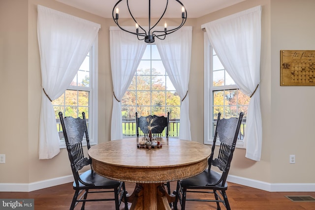 dining area featuring a notable chandelier and dark hardwood / wood-style floors