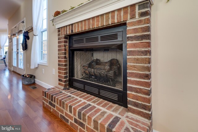 interior details featuring hardwood / wood-style flooring and a brick fireplace