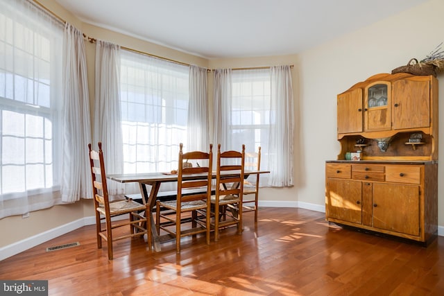 dining area featuring dark wood-type flooring and a healthy amount of sunlight