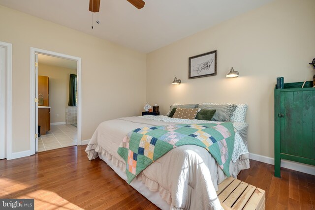 bedroom featuring ensuite bathroom, wood-type flooring, and ceiling fan