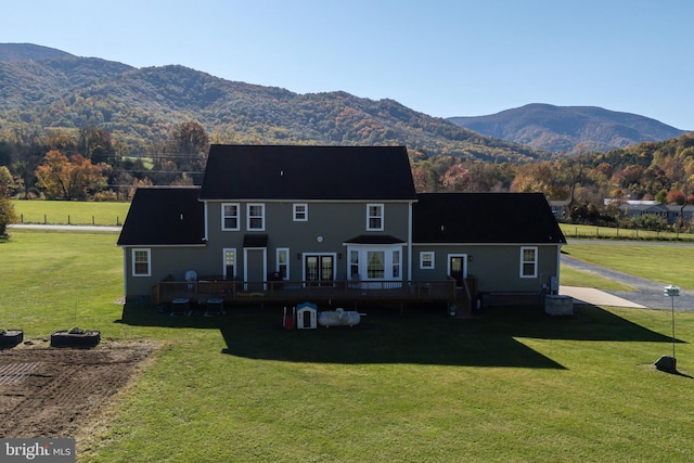 back of house with a yard and a deck with mountain view