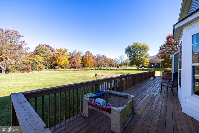 wooden deck featuring a lawn