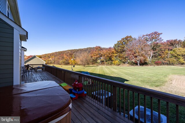 wooden deck with a yard and a hot tub