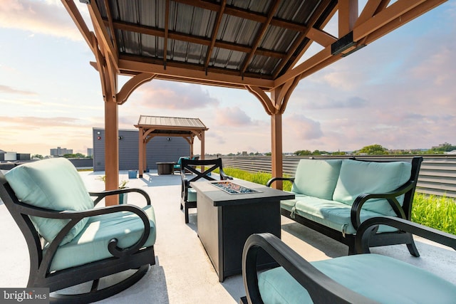 patio terrace at dusk with a gazebo and an outdoor living space with a fire pit