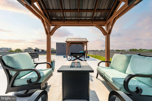 patio terrace at dusk featuring a gazebo and an outdoor living space with a fire pit