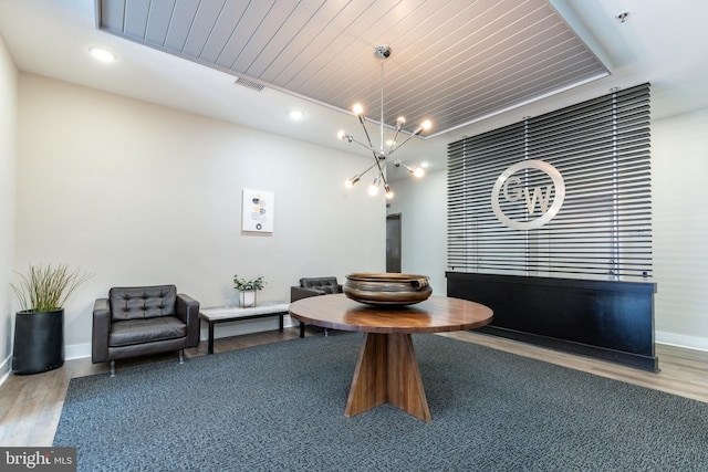 dining space with light hardwood / wood-style floors, a notable chandelier, and wooden ceiling