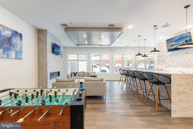 rec room featuring hardwood / wood-style floors and a fireplace