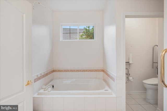 bathroom with tiled bath, toilet, and tile patterned floors