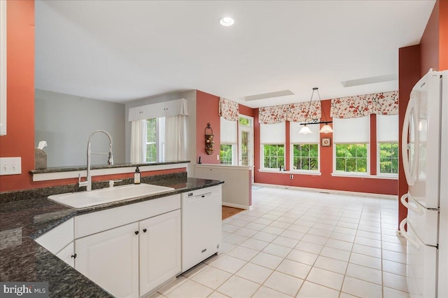 kitchen featuring white cabinetry, a wealth of natural light, pendant lighting, and white appliances