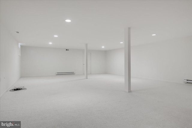 basement featuring baseboard heating and light colored carpet