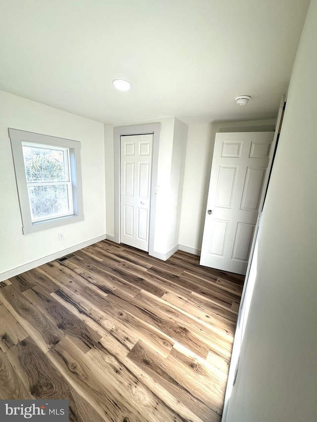 unfurnished bedroom featuring a closet and wood-type flooring