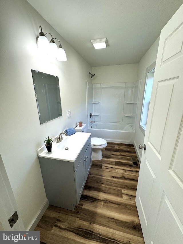 full bathroom featuring vanity, hardwood / wood-style flooring, tub / shower combination, and toilet