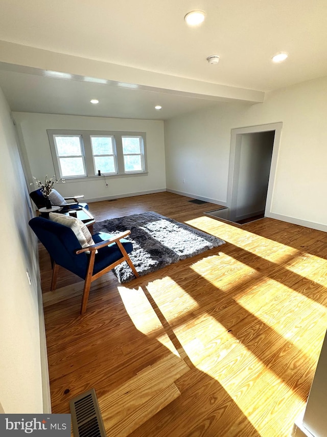 living room with wood-type flooring and beamed ceiling