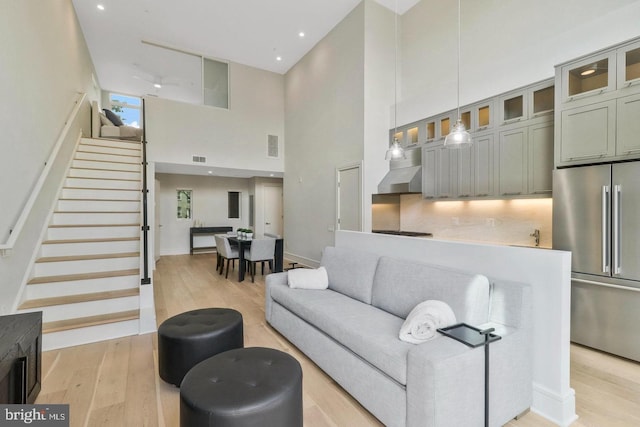 living room with a towering ceiling and light hardwood / wood-style floors