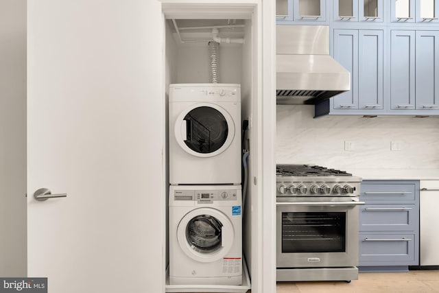 clothes washing area featuring stacked washing maching and dryer