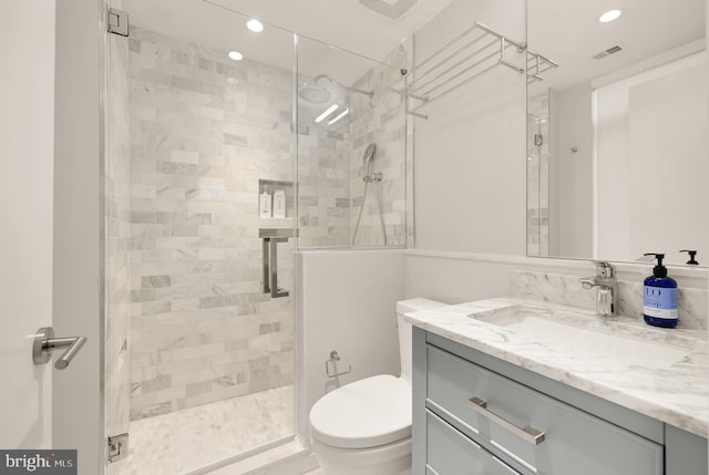 bathroom featuring vanity, an enclosed shower, and toilet