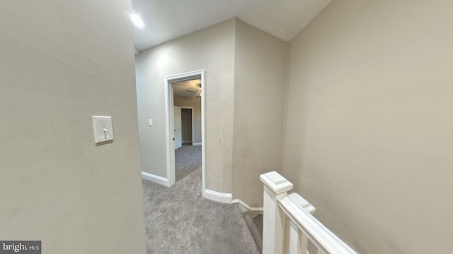 corridor with vaulted ceiling and light carpet