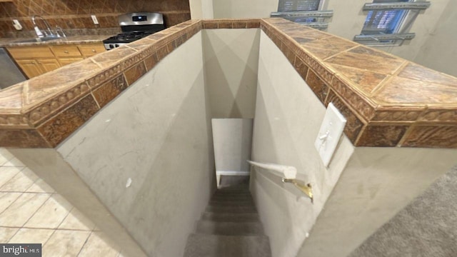 stairway featuring sink and tile patterned flooring