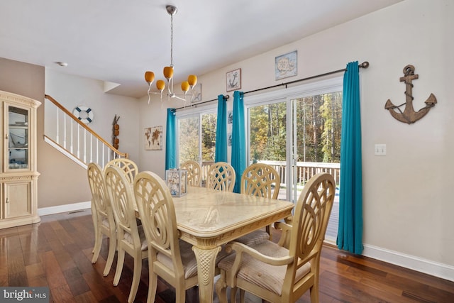 dining room with dark hardwood / wood-style flooring and an inviting chandelier