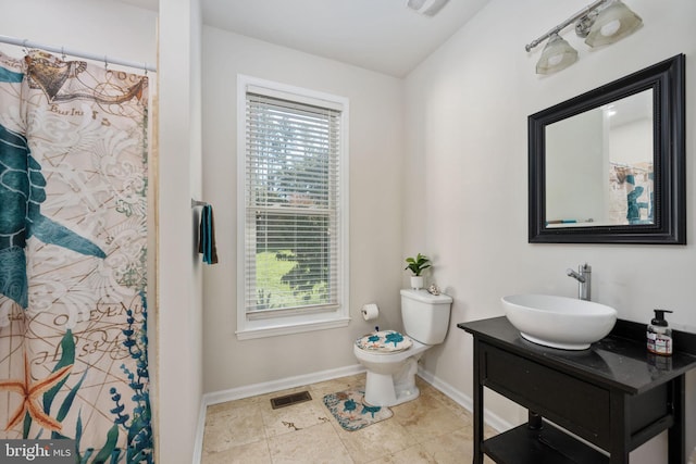 bathroom featuring vanity, walk in shower, and toilet