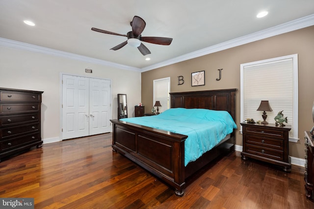 bedroom with crown molding, dark wood-type flooring, ceiling fan, and a closet