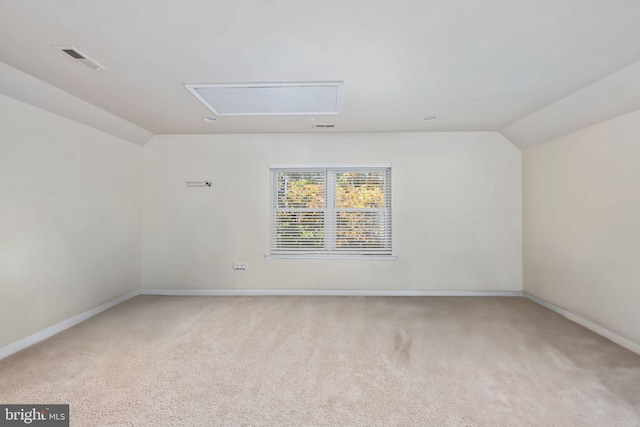 empty room featuring lofted ceiling and light carpet