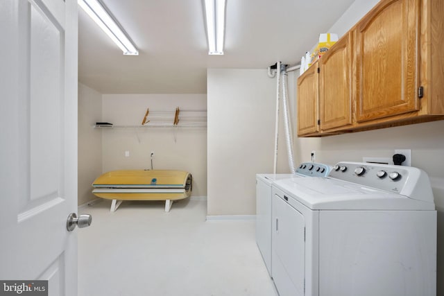 washroom featuring separate washer and dryer and cabinets