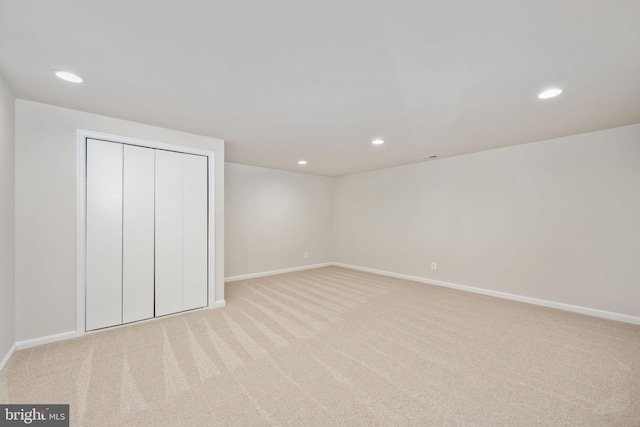 unfurnished bedroom featuring light colored carpet and a closet