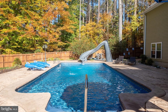 view of pool featuring a patio area and a water slide