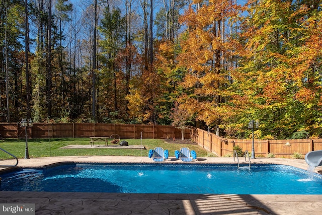 view of swimming pool featuring pool water feature, a yard, and a water slide