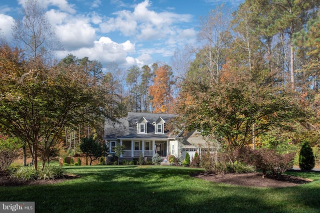 cape cod-style house featuring a front lawn and covered porch