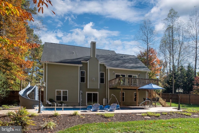 back of property featuring a fenced in pool and a patio area