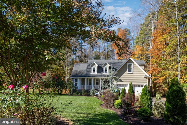 new england style home with a porch, a garage, and a front lawn