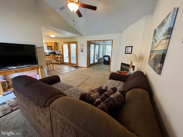 living room with light hardwood / wood-style flooring, lofted ceiling, french doors, and ceiling fan