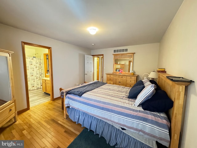 bedroom featuring connected bathroom and light wood-type flooring