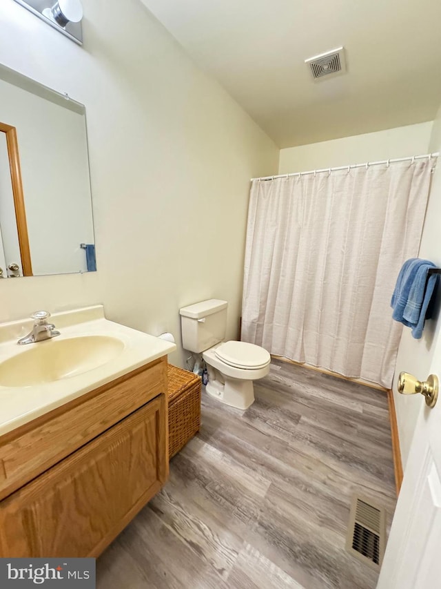 bathroom featuring vanity, hardwood / wood-style floors, and toilet