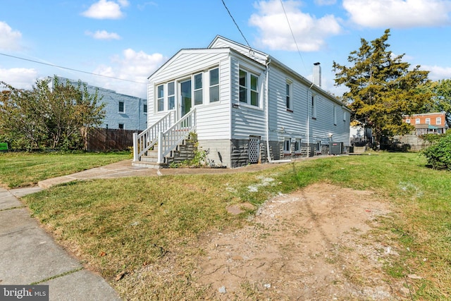 view of side of home featuring central AC unit and a yard