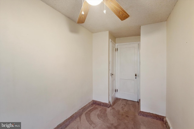 carpeted spare room featuring a textured ceiling and ceiling fan