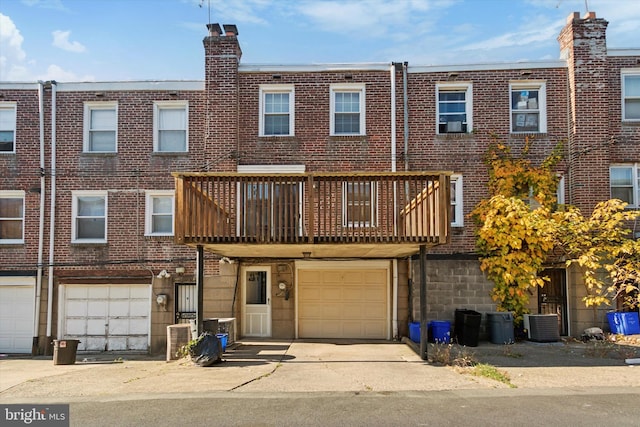 multi unit property featuring cooling unit, a garage, and a balcony