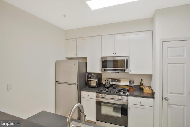 kitchen with appliances with stainless steel finishes and white cabinets