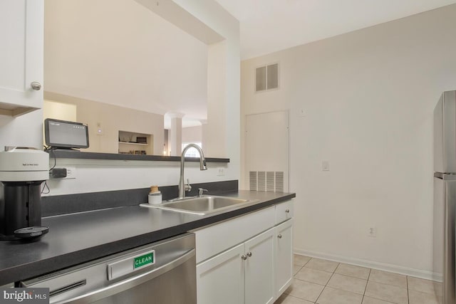 kitchen featuring ornate columns, stainless steel appliances, sink, light tile patterned flooring, and white cabinets