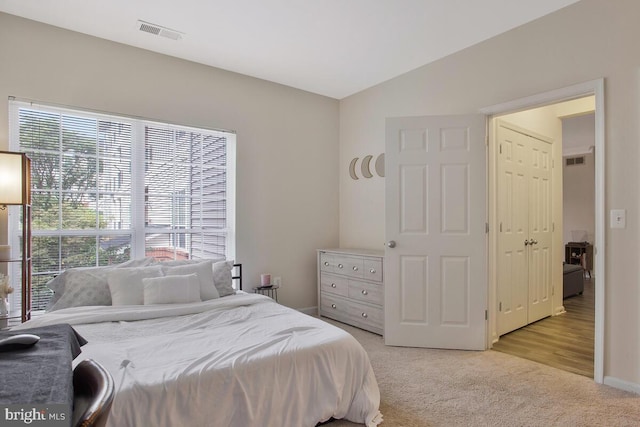 bedroom featuring light carpet, multiple windows, and vaulted ceiling