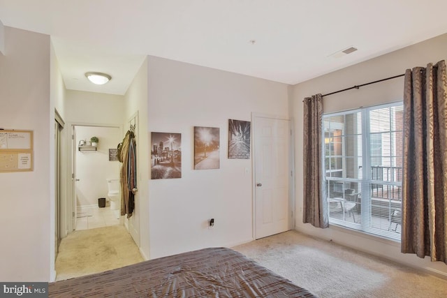 carpeted bedroom featuring ensuite bath