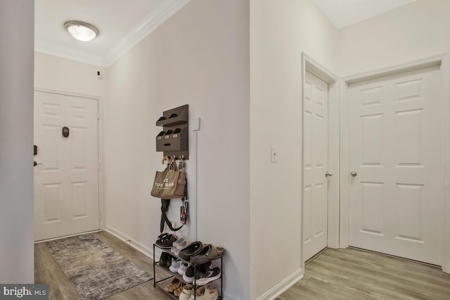 foyer entrance featuring crown molding and light hardwood / wood-style flooring