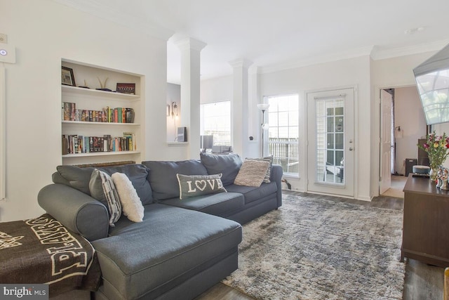 living room with crown molding, built in shelves, ornate columns, and dark hardwood / wood-style flooring