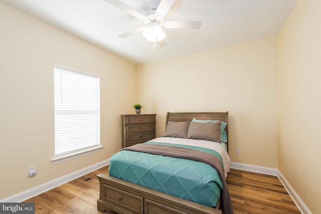 bedroom with multiple windows, hardwood / wood-style flooring, and ceiling fan